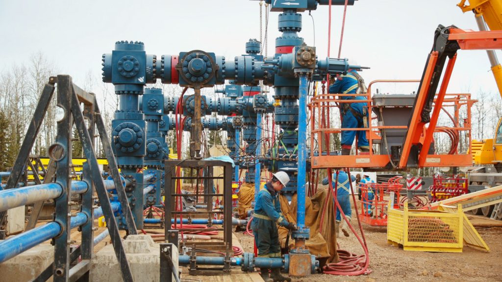 Workers performing maintenance on wellhead solutions in the field